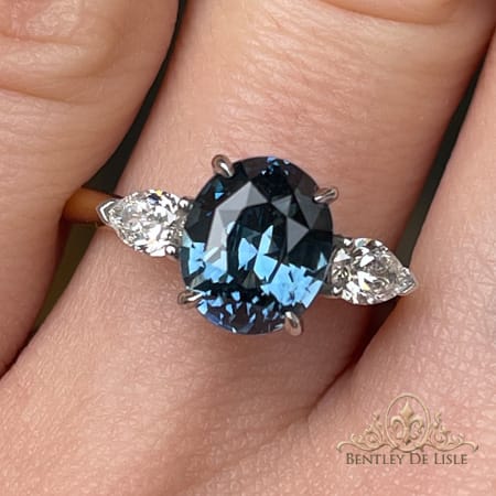 Oval-blue-sapphire-pear-diamond-ring-hand-bentley-de-lisle
